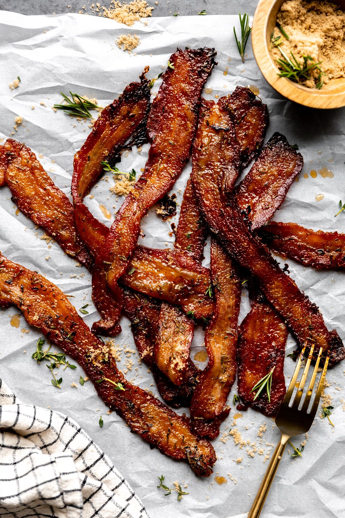 Herb Candied Bacon arranged on parchment paper.