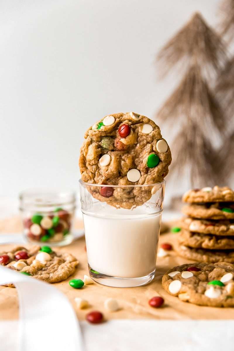 A cookie butter monster cookie sitting on top of a glass of milk.