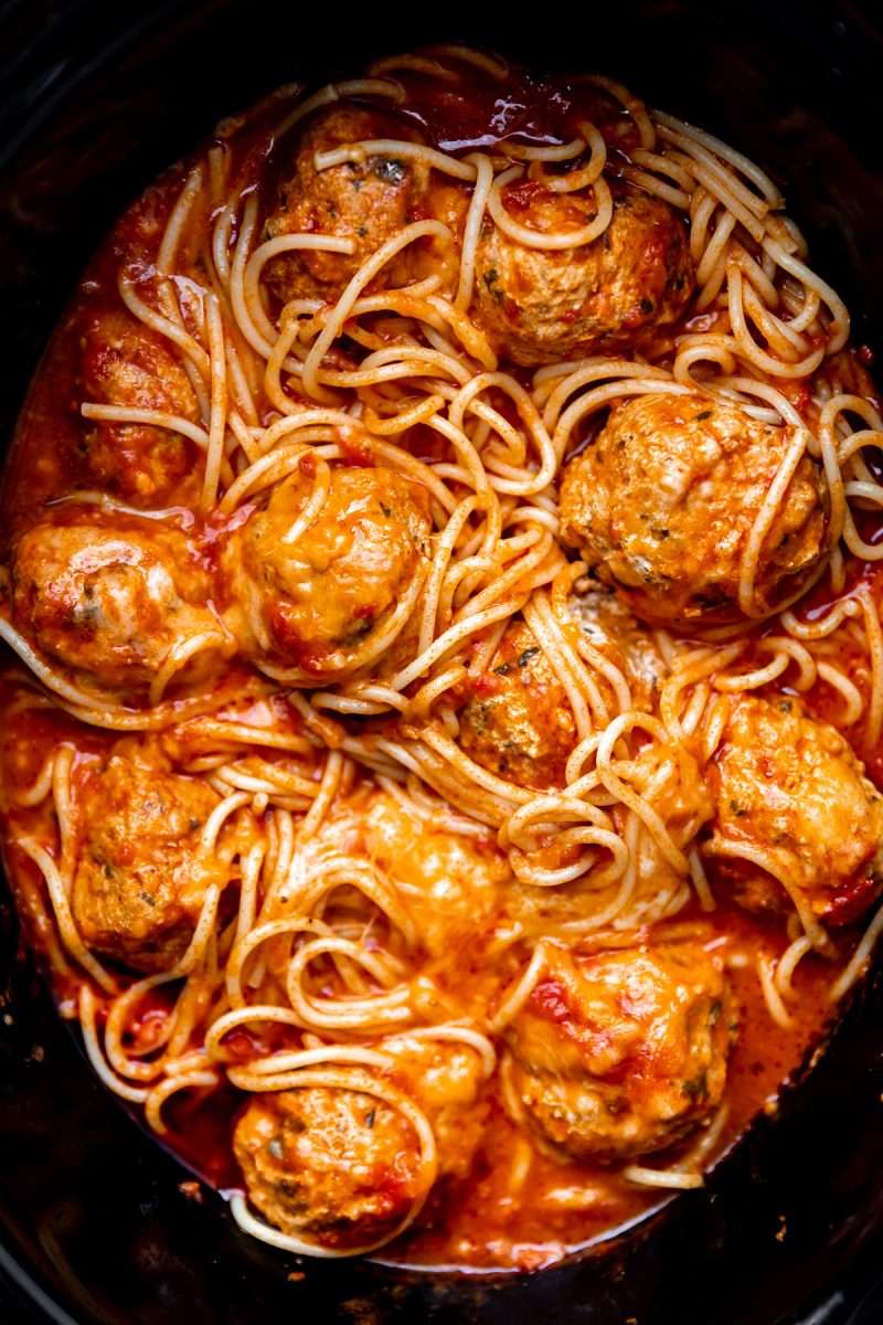Slow Cooker Chicken Parmesan Meatballs with spaghetti in a slow cooker.