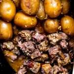 Slow Cooker Garlic Butter Beef Bites and potatoes in a slow cooker.
