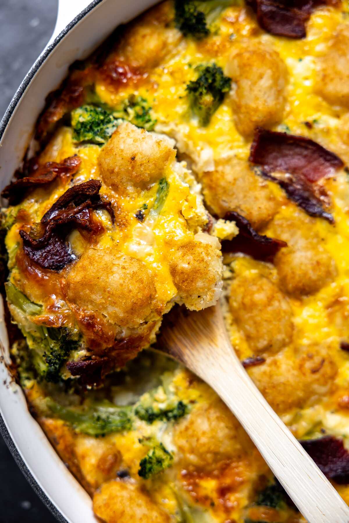 A serving spoon taking some of the breakfast casserole out. 