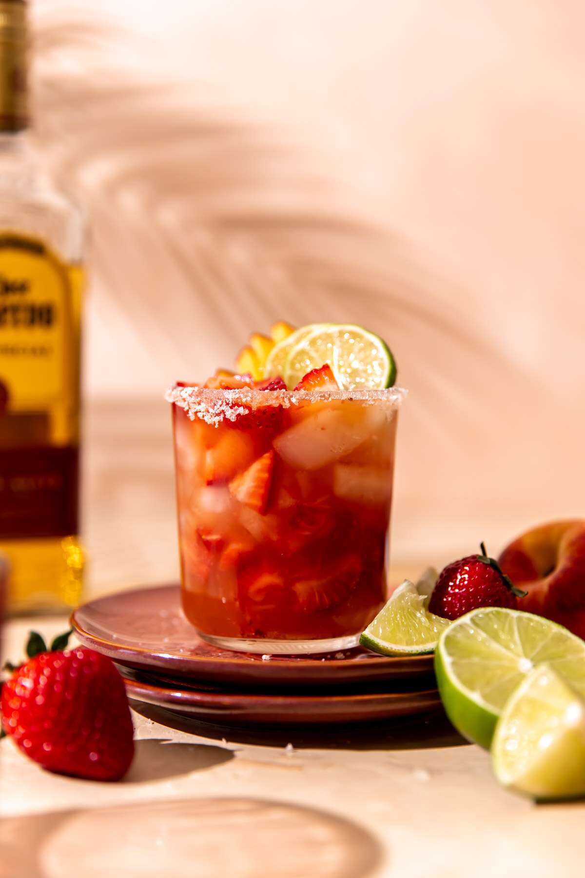 A Strawberry Smash Peach Margarita sitting in direct light waiting to be sipped on!