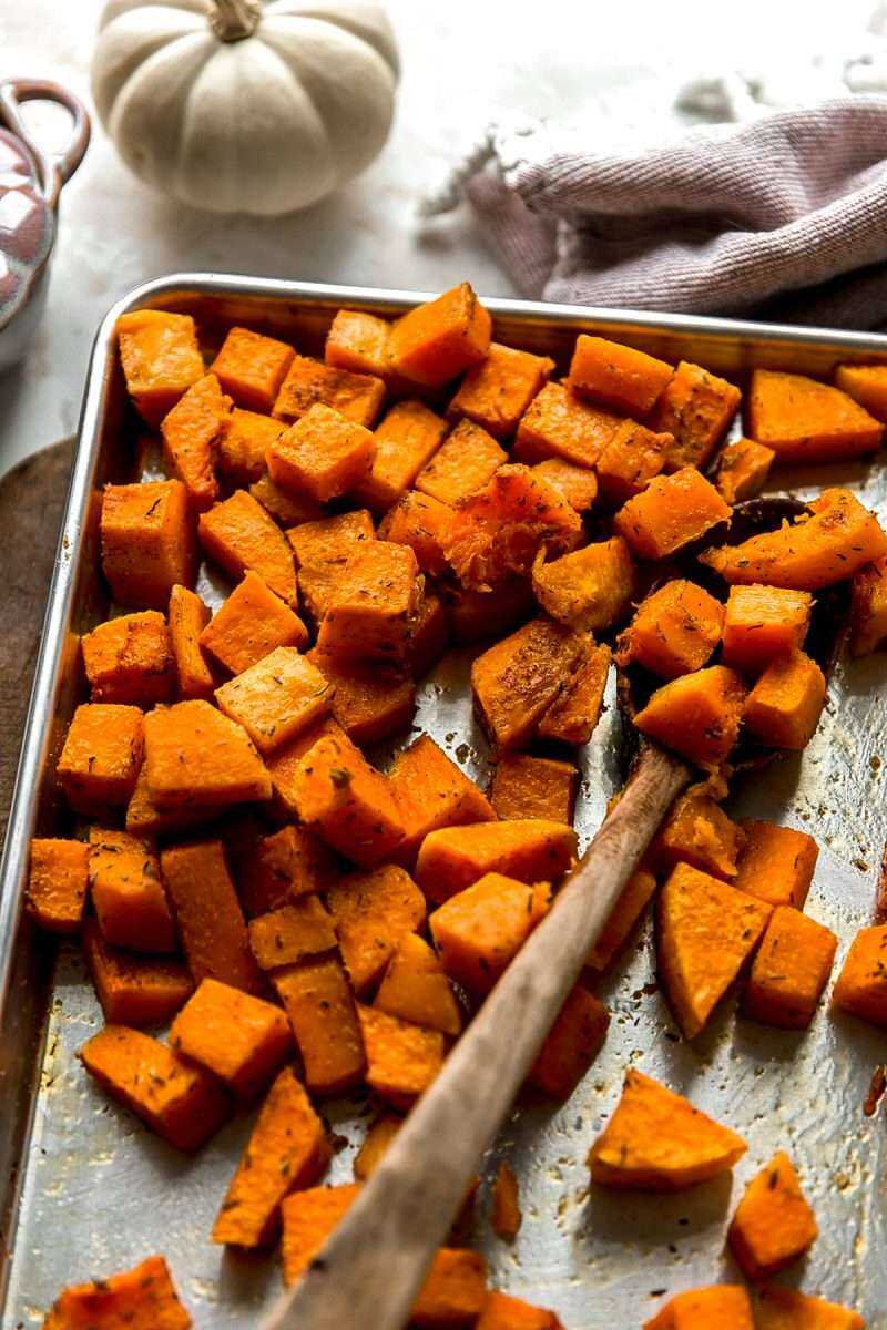 Roasted butternut squash cubes on a sheet pan.