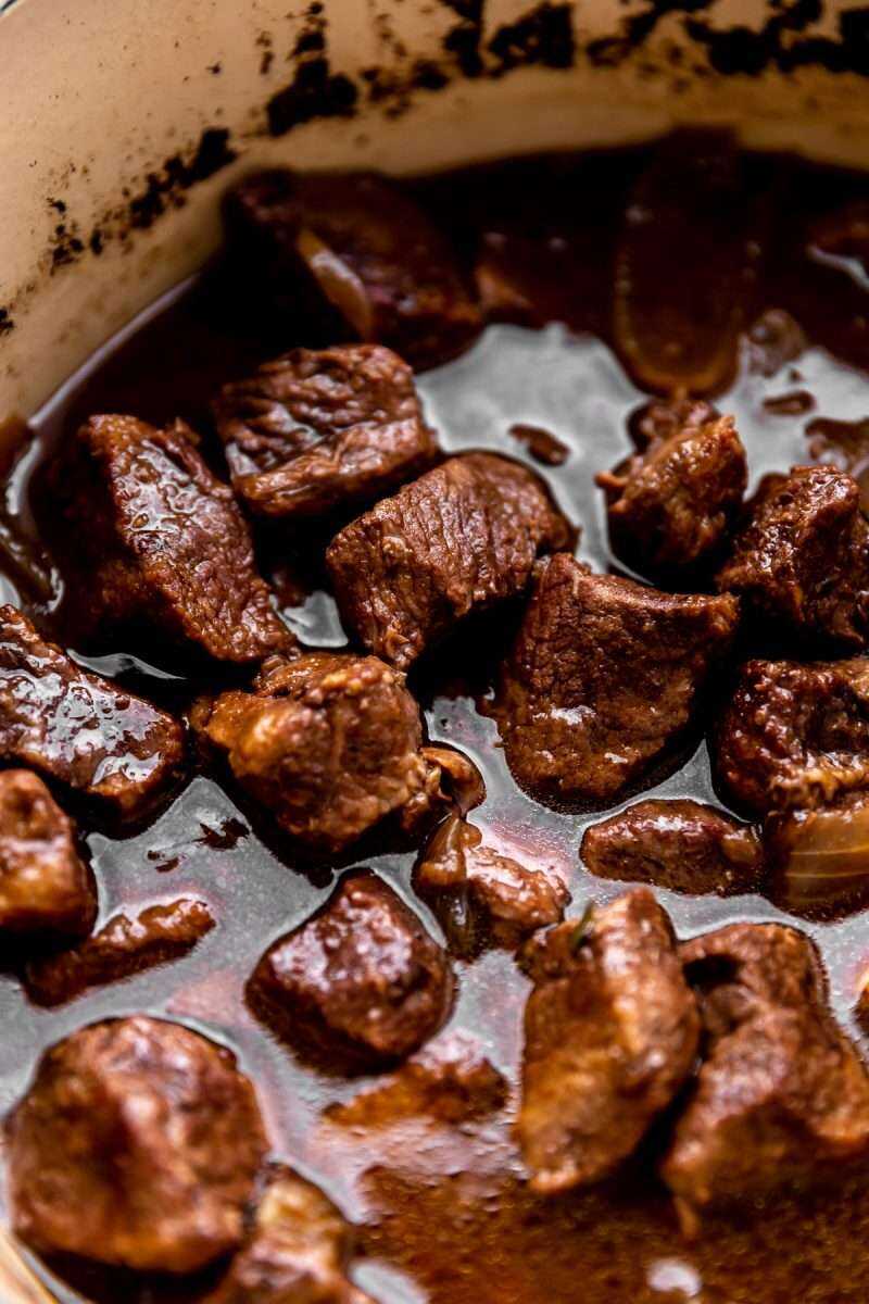 A close-up photo of Red Wine Braised Beef Tips in a Dutch oven.