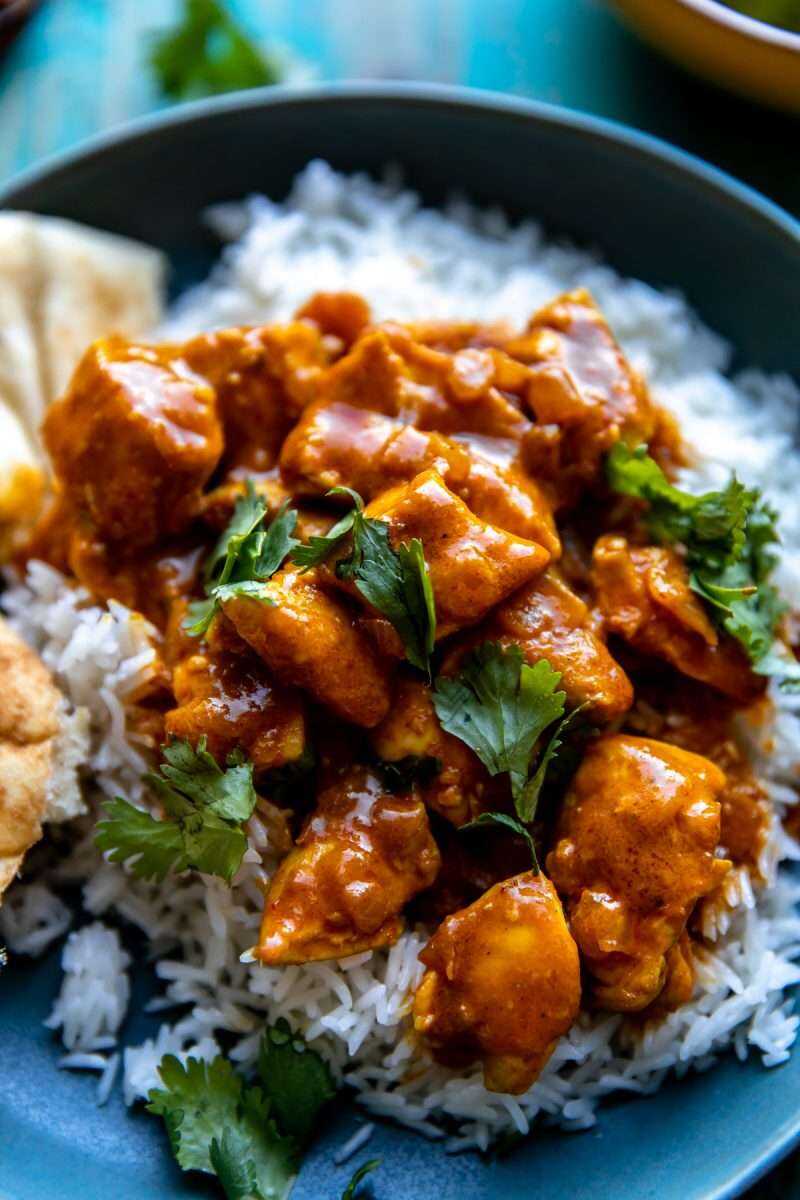 A close-up photo of Easy Coconut Chicken Curry served with rice and naan bread.