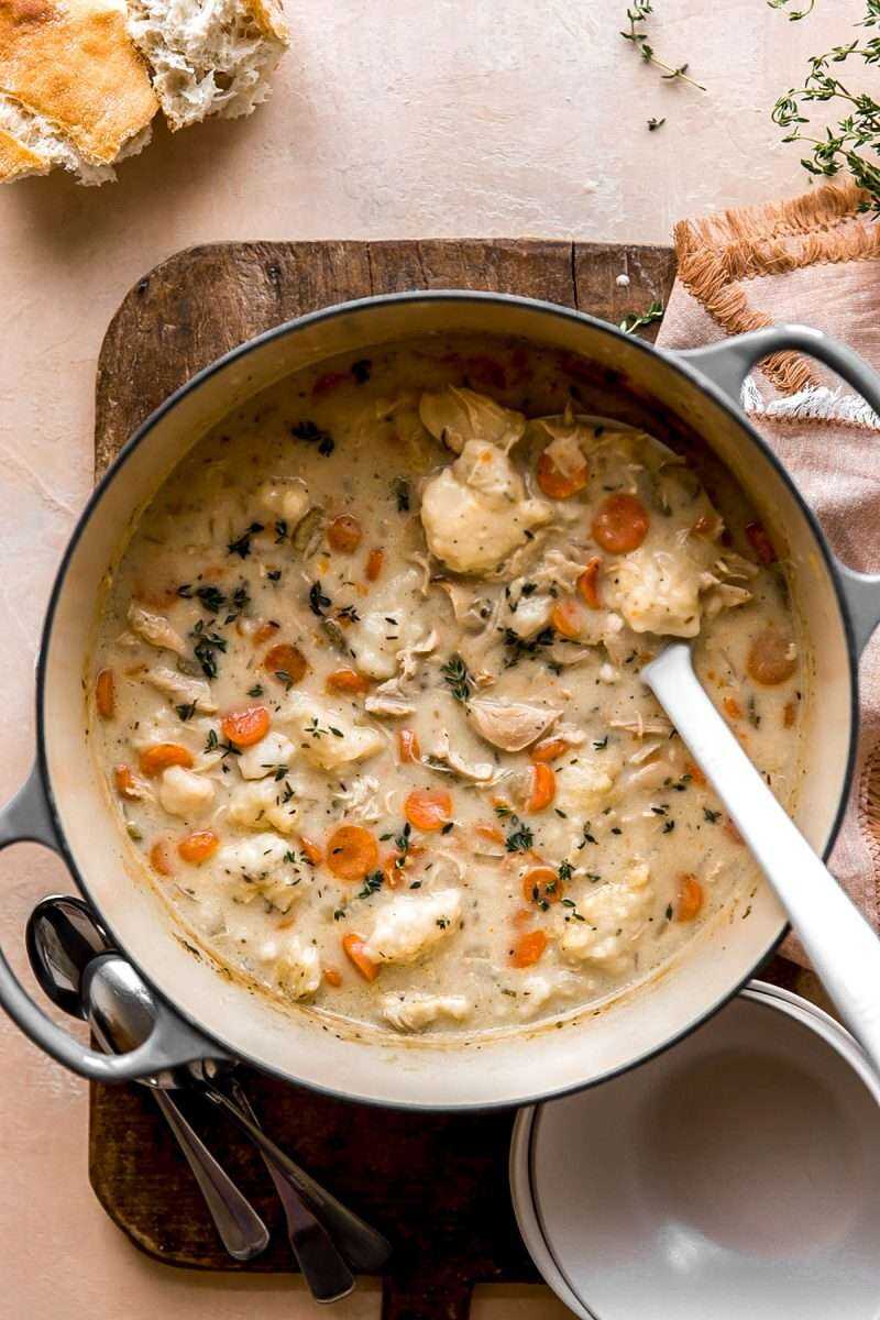 Chicken and Dumplings Soup in a pot with a ladel.