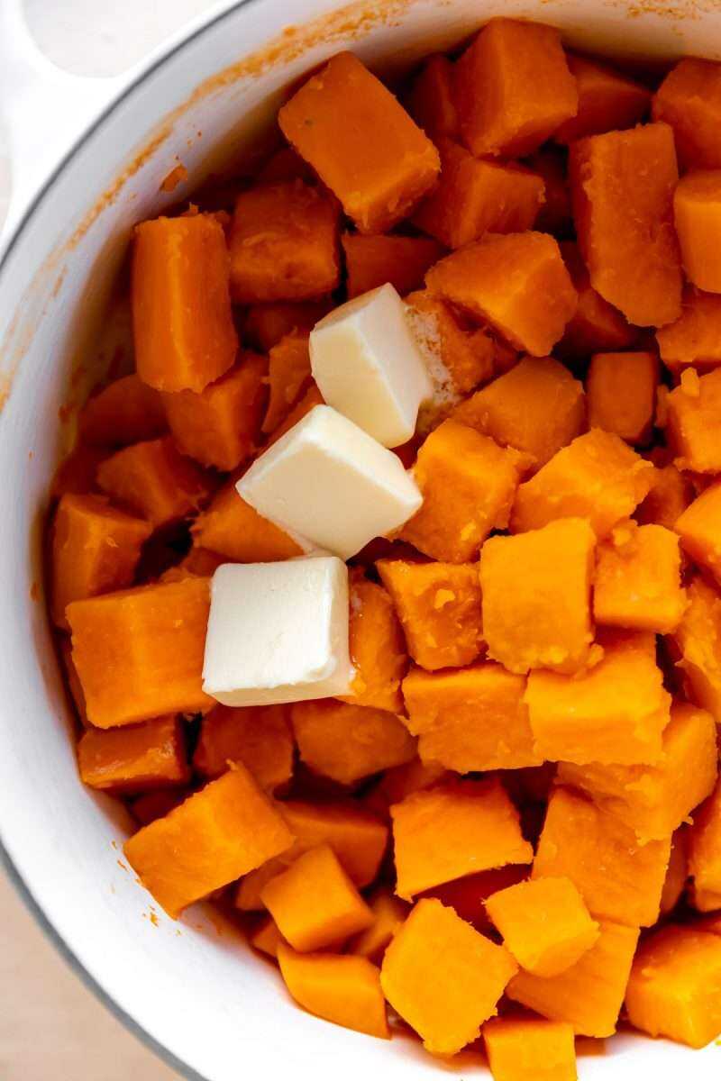 Boiled sweet potatoes in a pot with butter.