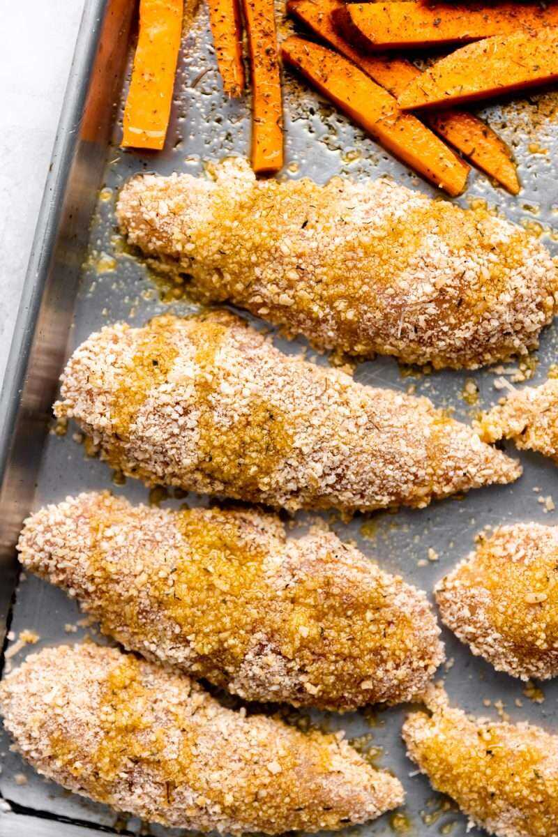 A close-up photo of the breaded chicken fingers ready for the oven.