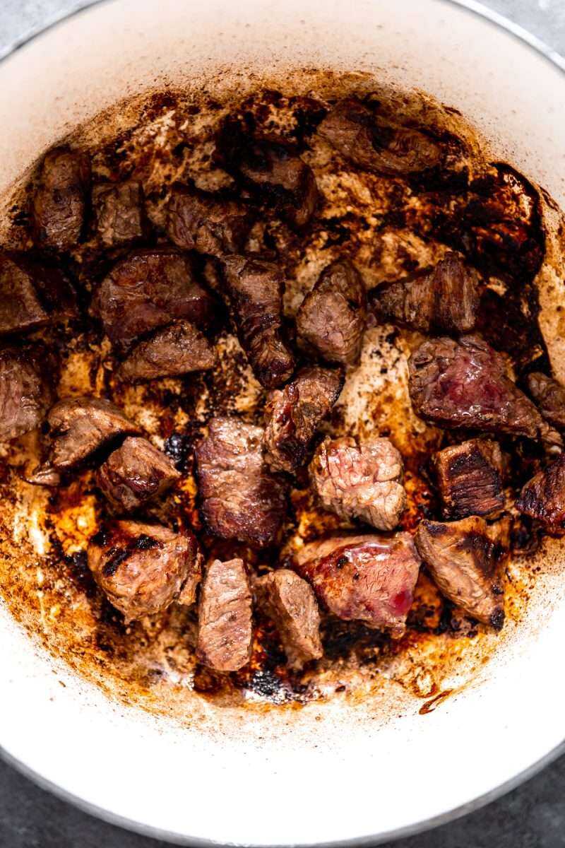 Seared beef stew meat in a pot.