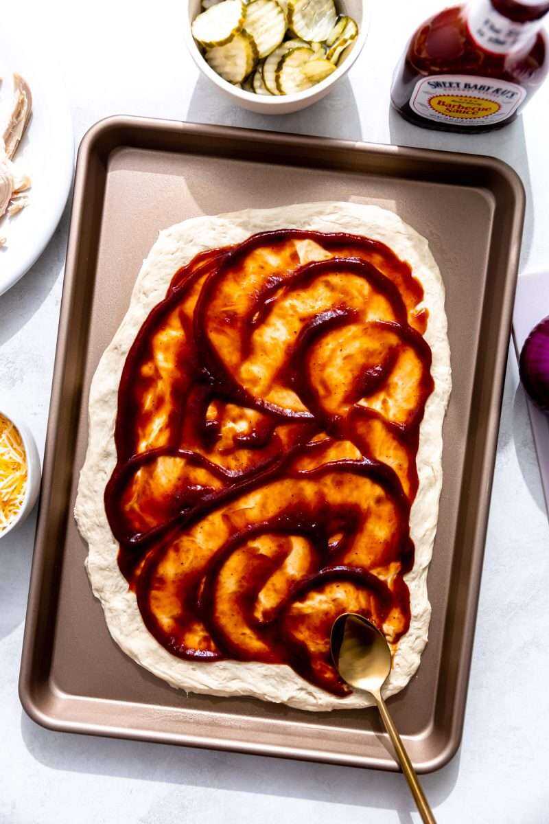 Bbq sauce smeared over the top of a pizza crust.