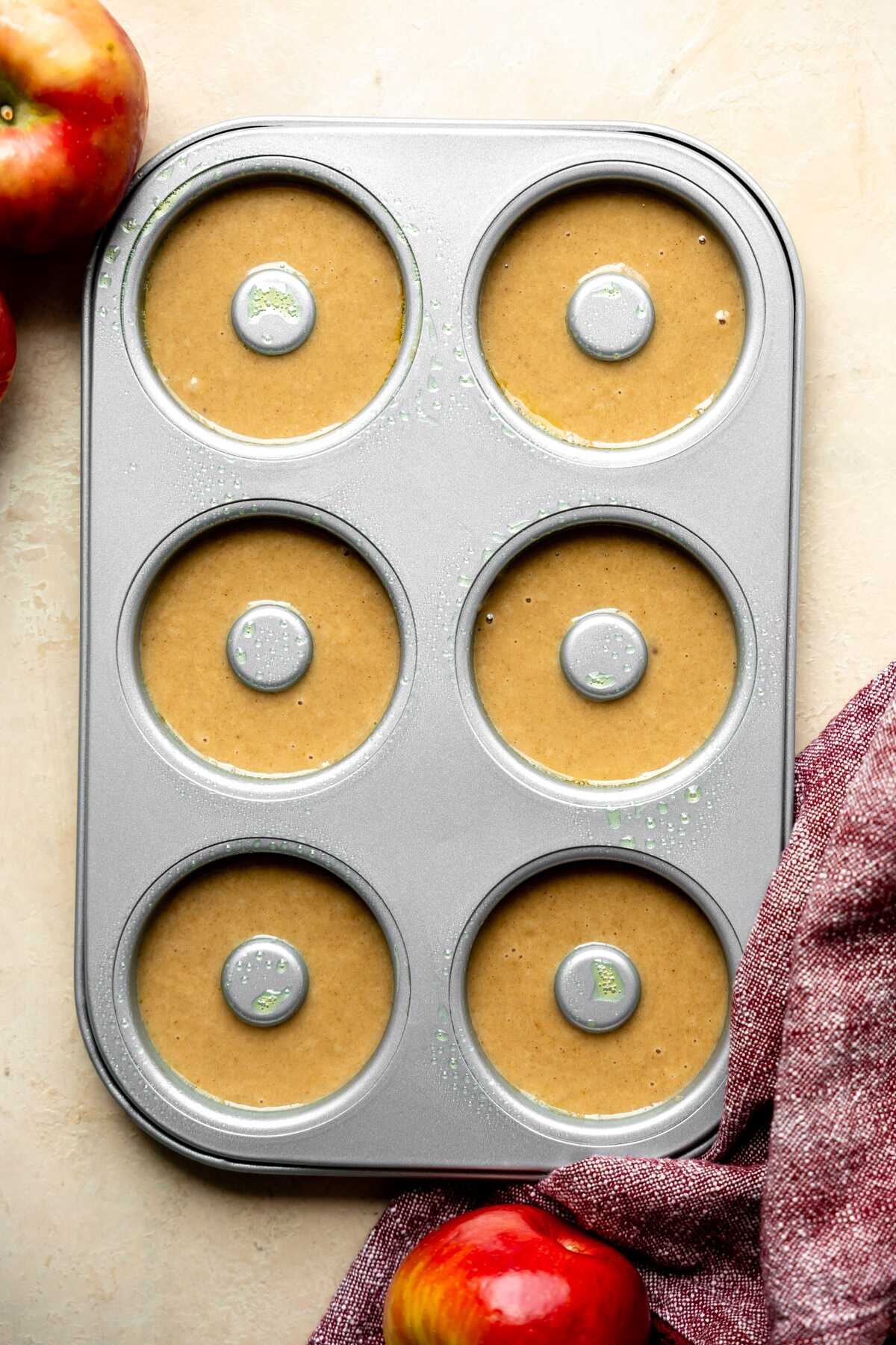 Apple cider donut batter in a donut pan ready for the oven.