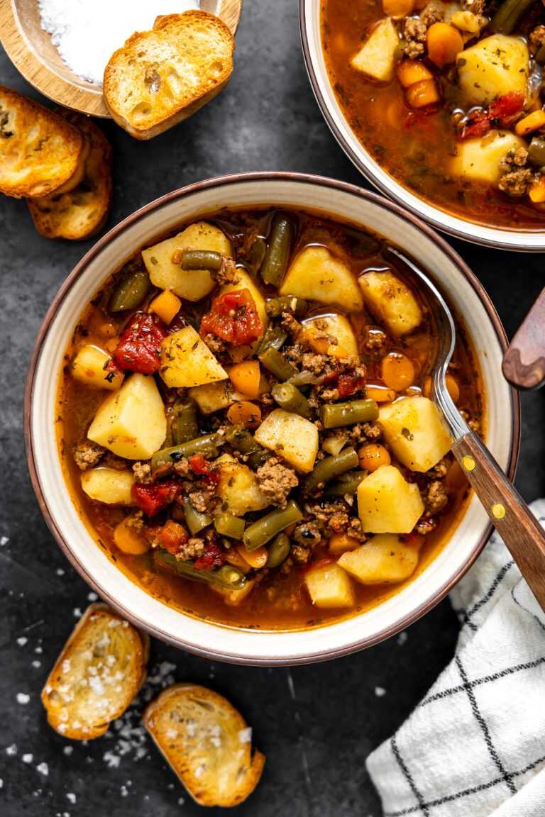Hamburger Soup in a bowl with crusty bread around.