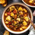 Hamburger Soup in a bowl with crusty bread around.