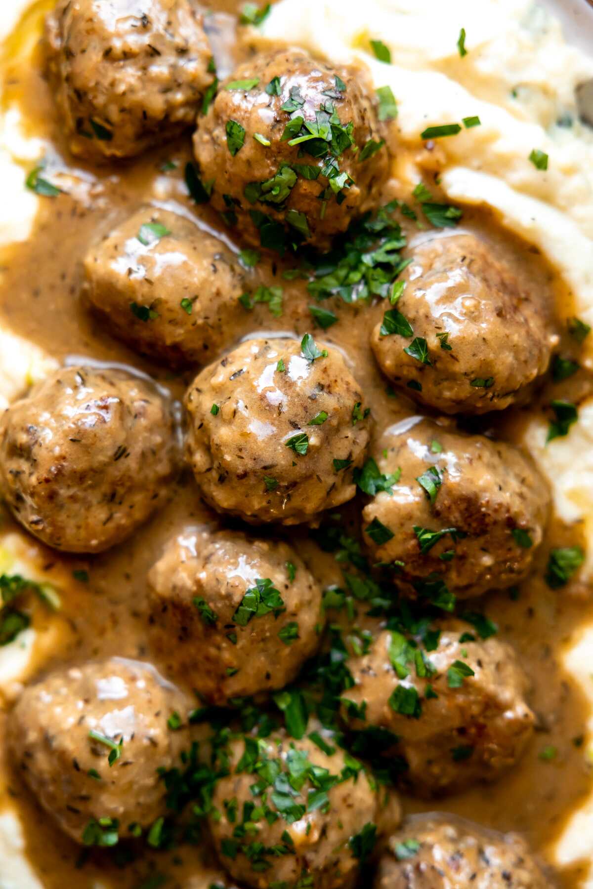 A close-up photo of herbed turkey meatballs with gravy. 