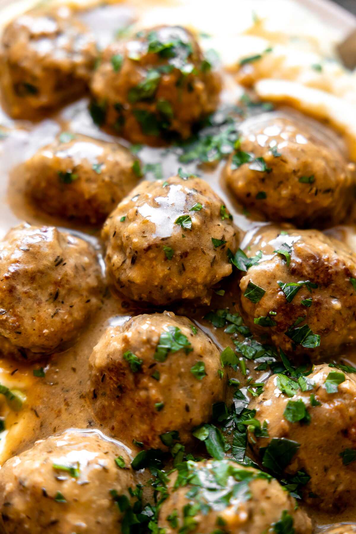 A close-up photo of herbed turkey meatballs with gravy. 