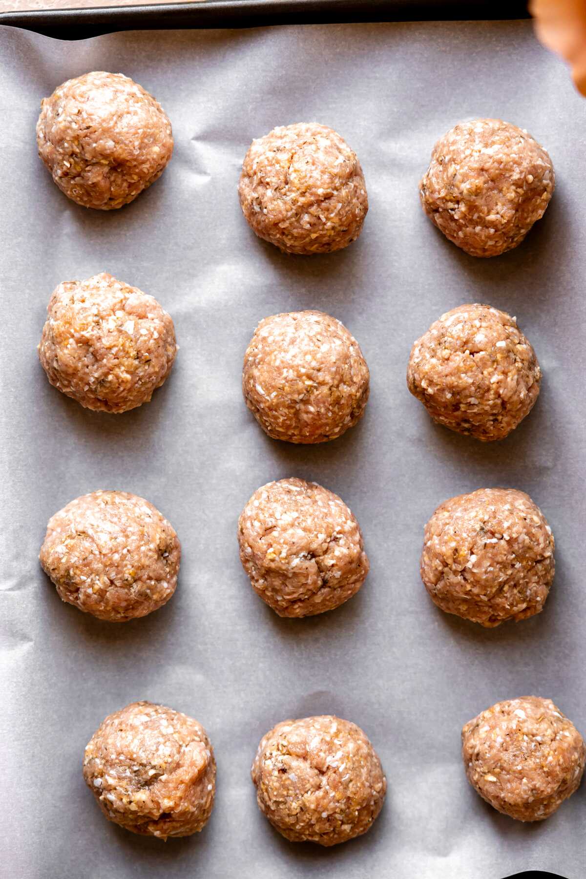 Rolled turkey meatballs on a baking sheet. 