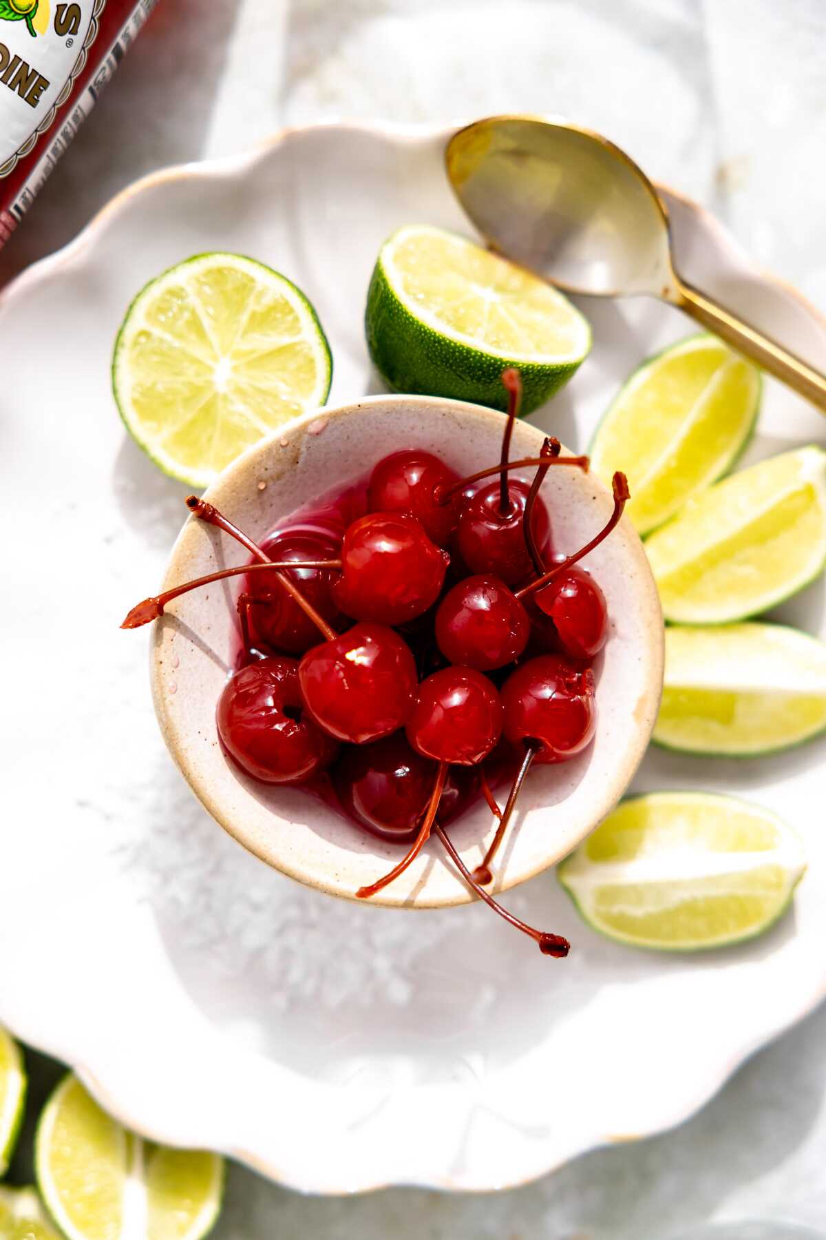 Cherries in a bowl with lime wedges. 