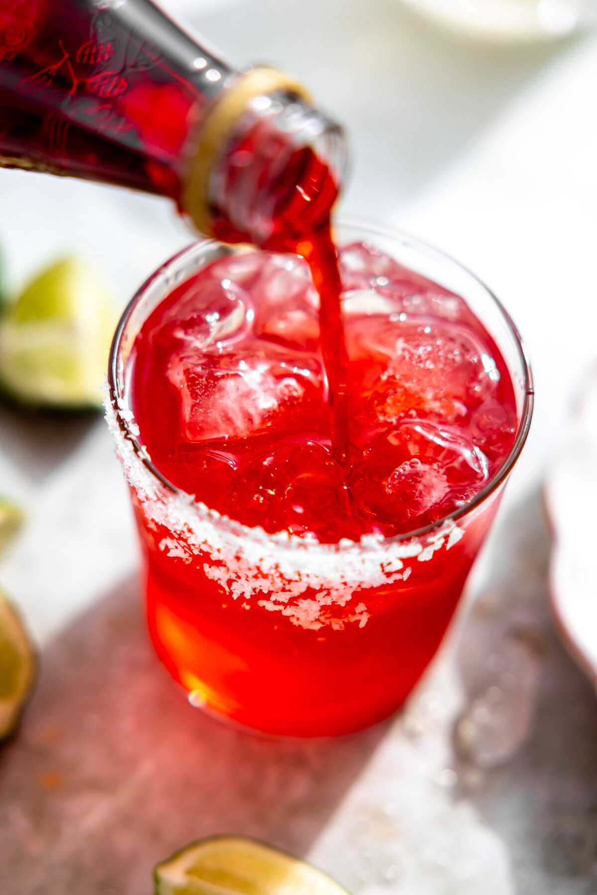 Grenadine being poured into the cocktail. 