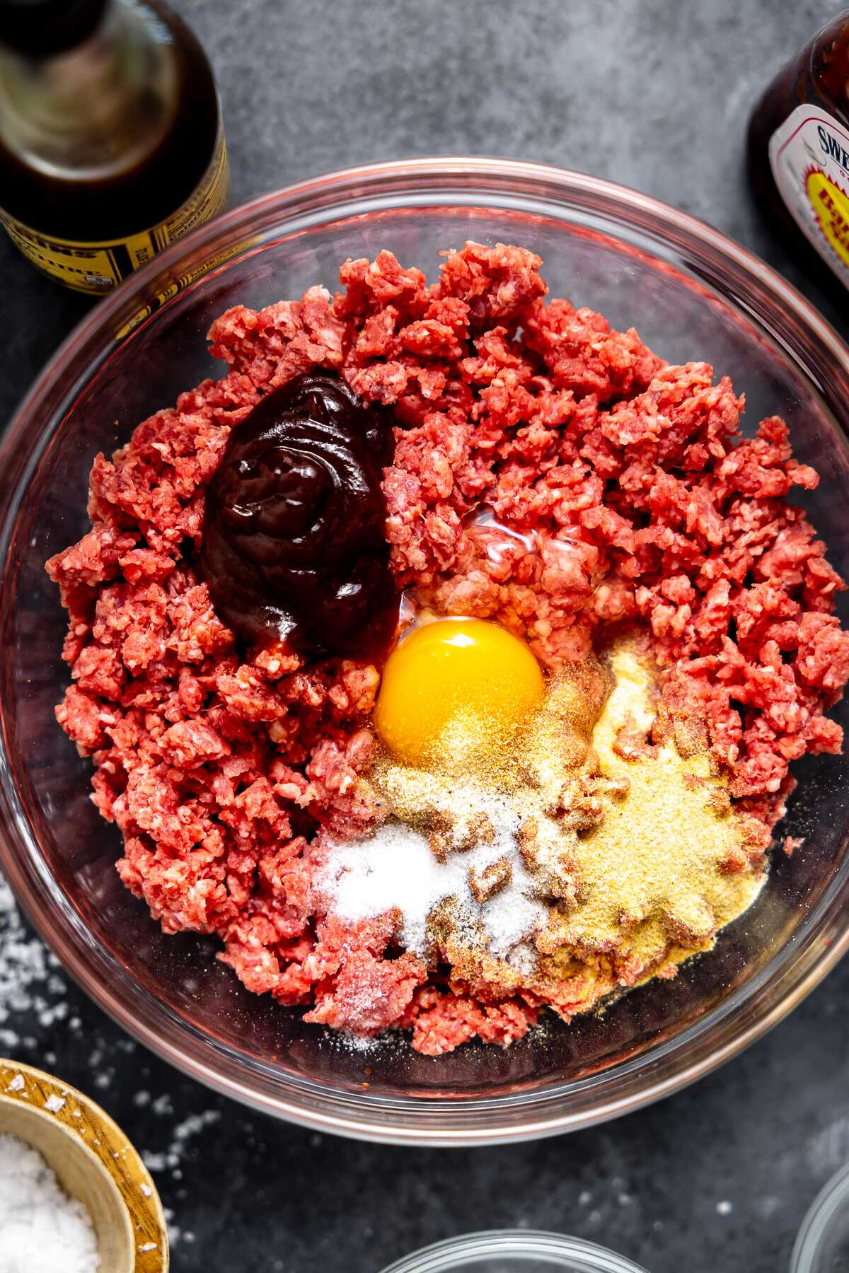 The burger ingredients being mixed into the ground beef. 