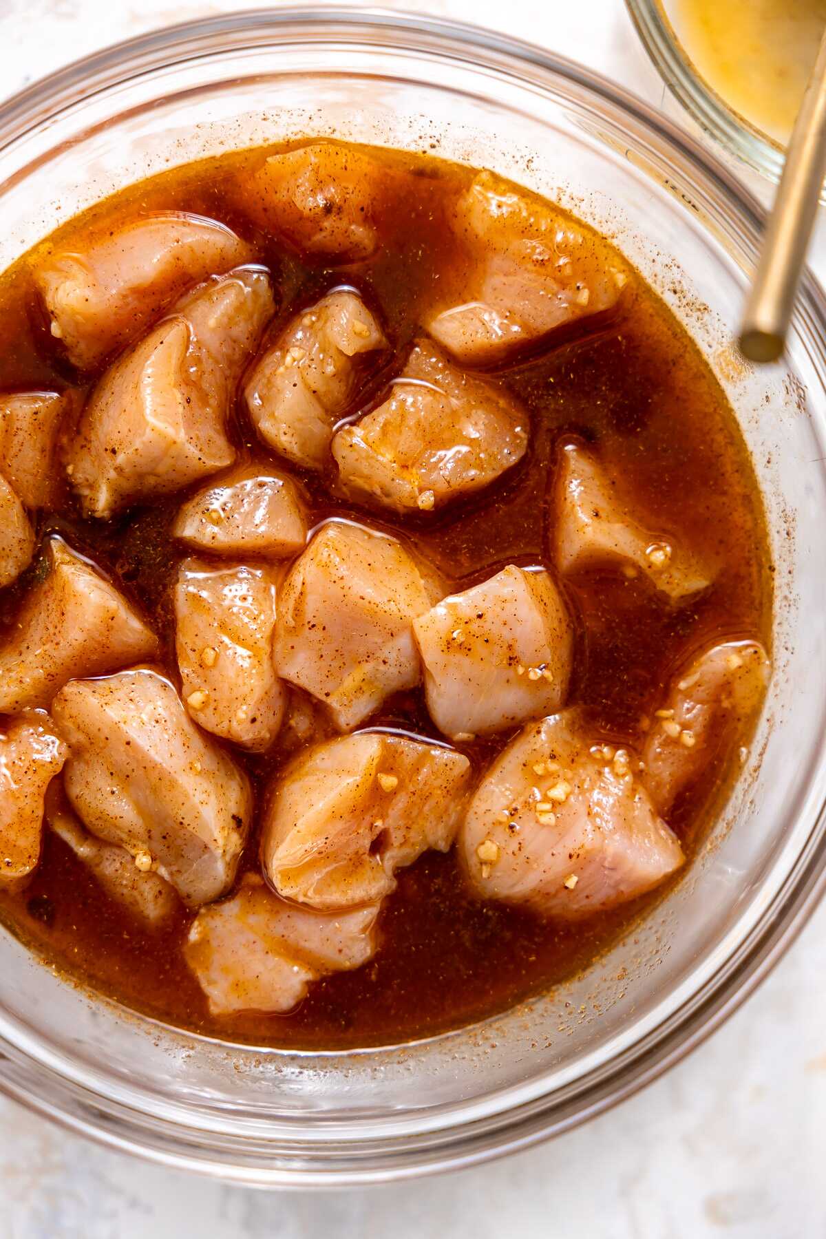 Chicken marinating in a bowl. 