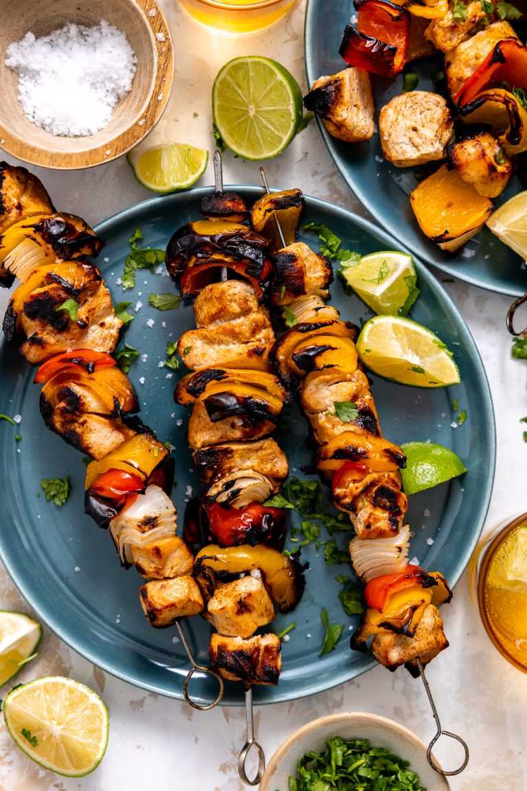 Grilled chicken fajita kabobs served on blue plates.