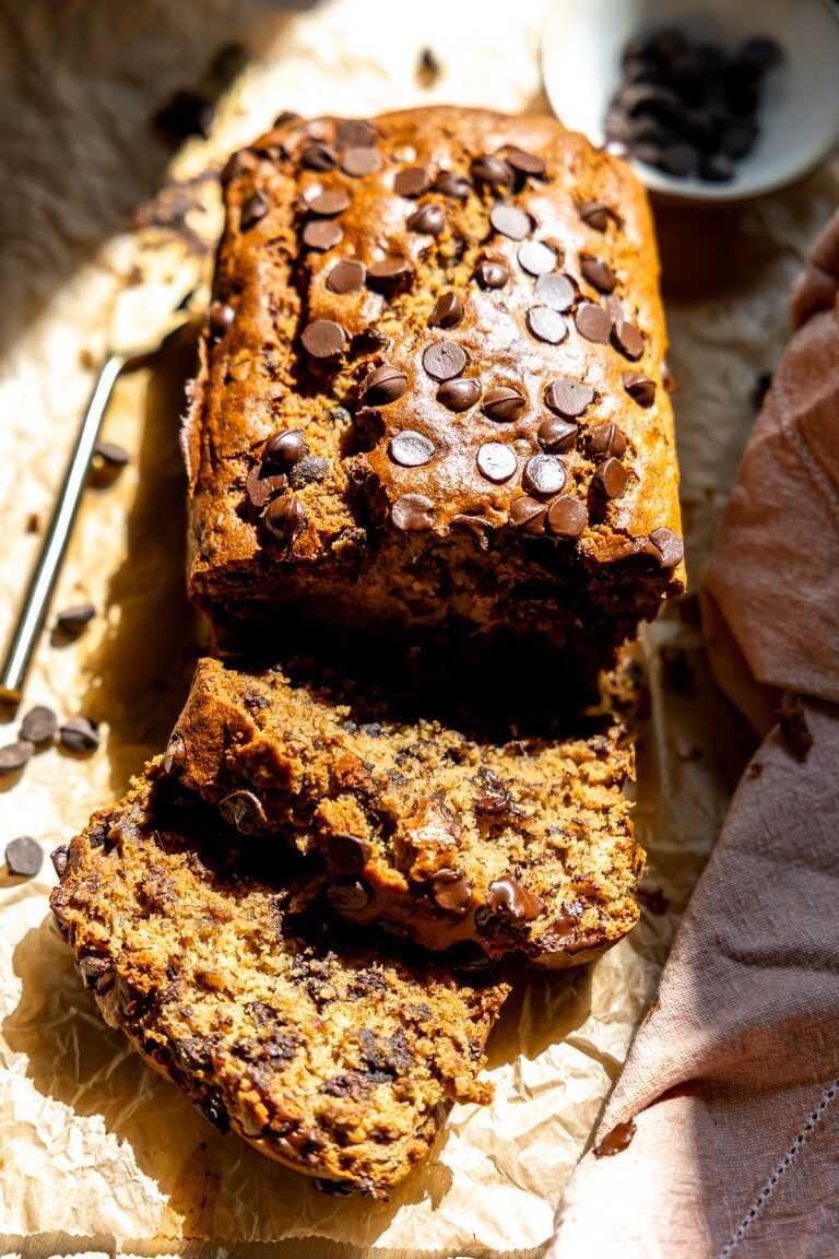 A loaf of gluten free chocolate chip banana bread sliced and ready to serve.