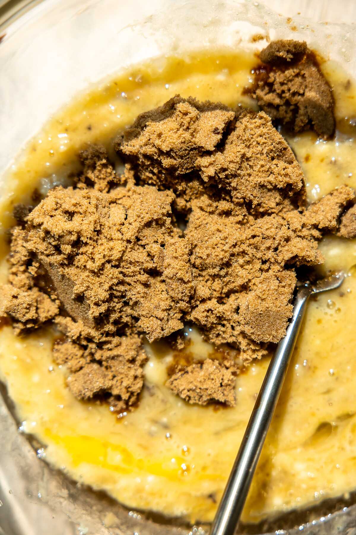 Brown sugar being mixed into the banana bread batter. 