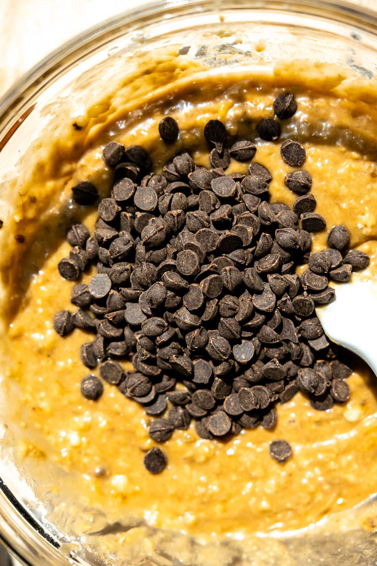 Chocolate chips being mixed into the banana bread batter. 
