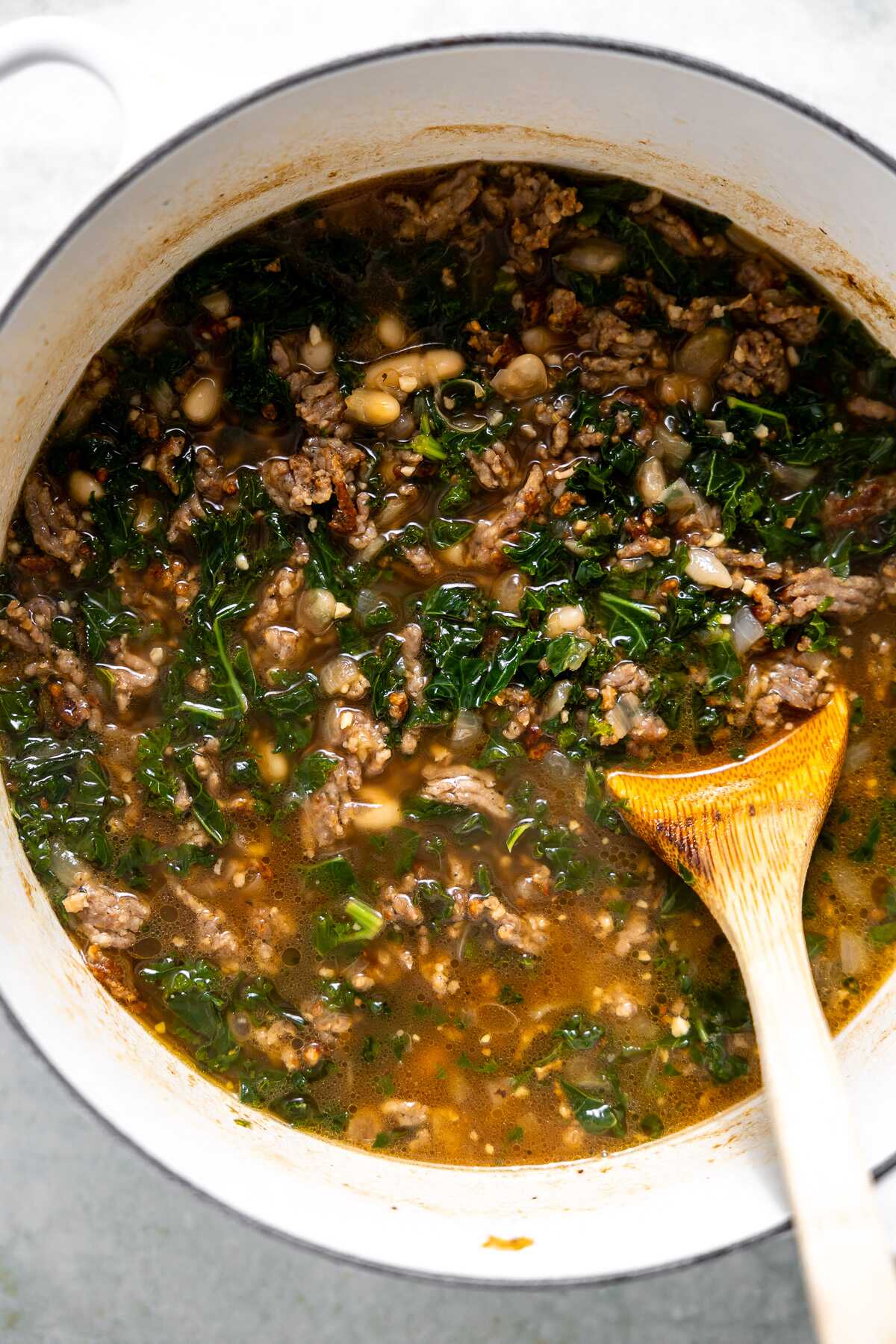 browned sausage, kale simmering in a pot