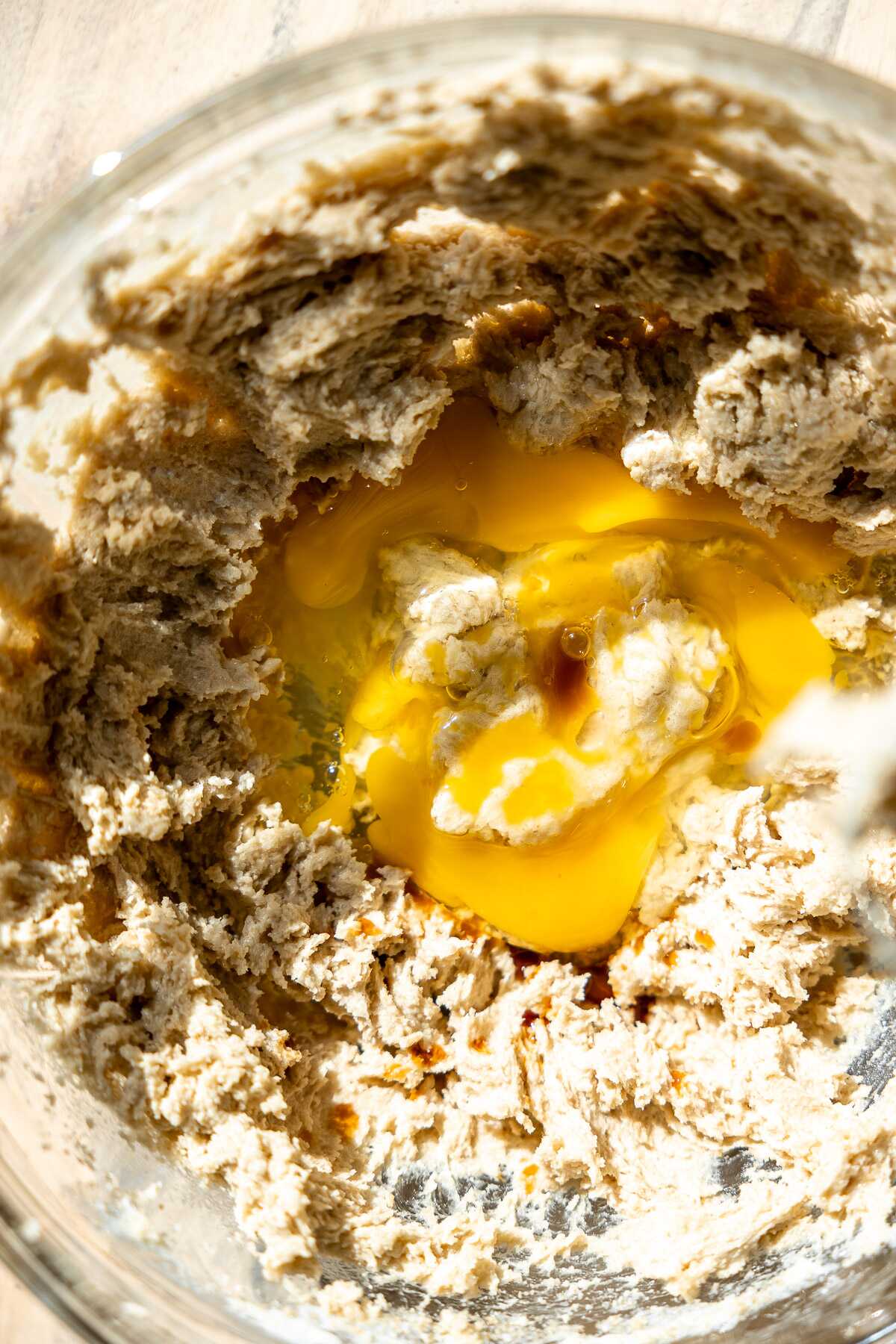 chocolate chip cookie pie dough in a bowl with cracked eggs in middle.<br />
