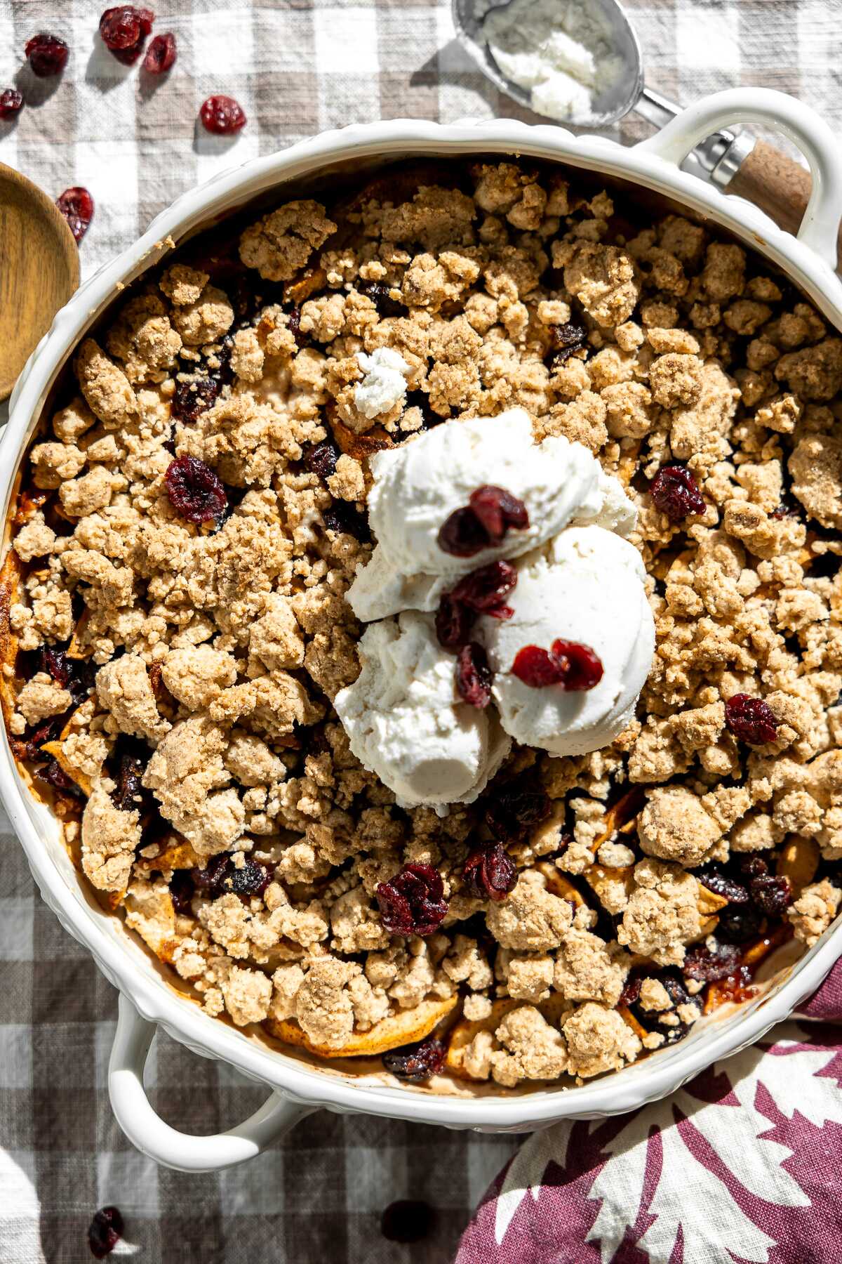 baked cranberry apple crumble with three scoops of vanilla icream in the middle 