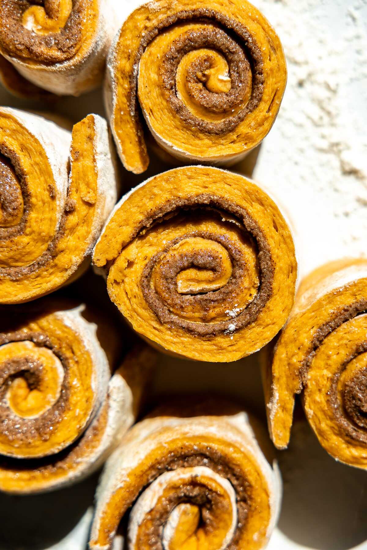an overhead shot of pumpkin cinnamon rolls rolled up and cut