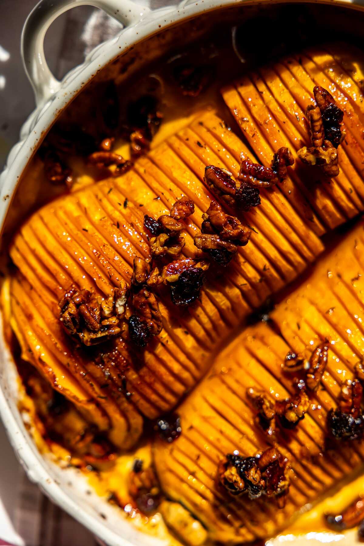 Honey Pecan Hassleback Butternut Squash in a roasting pan on the table.