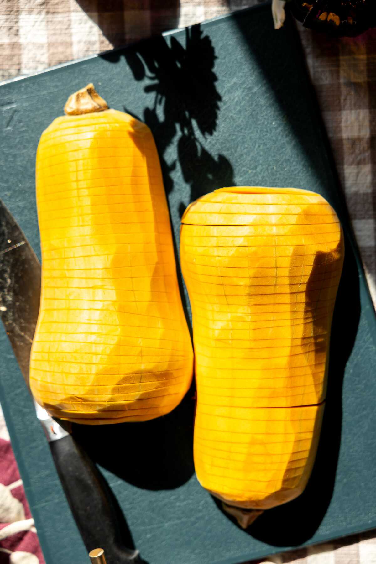 A hassleback butternut squash on a cutting board. 