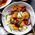 Sheet pan cajun chicken meatballs served over a bed of rice garnished with green onions.