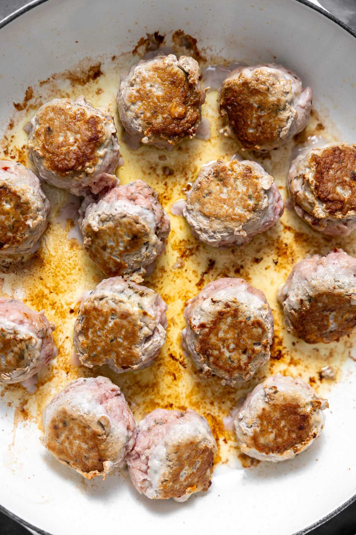 Seared spicy turkey meatballs in a skillet.