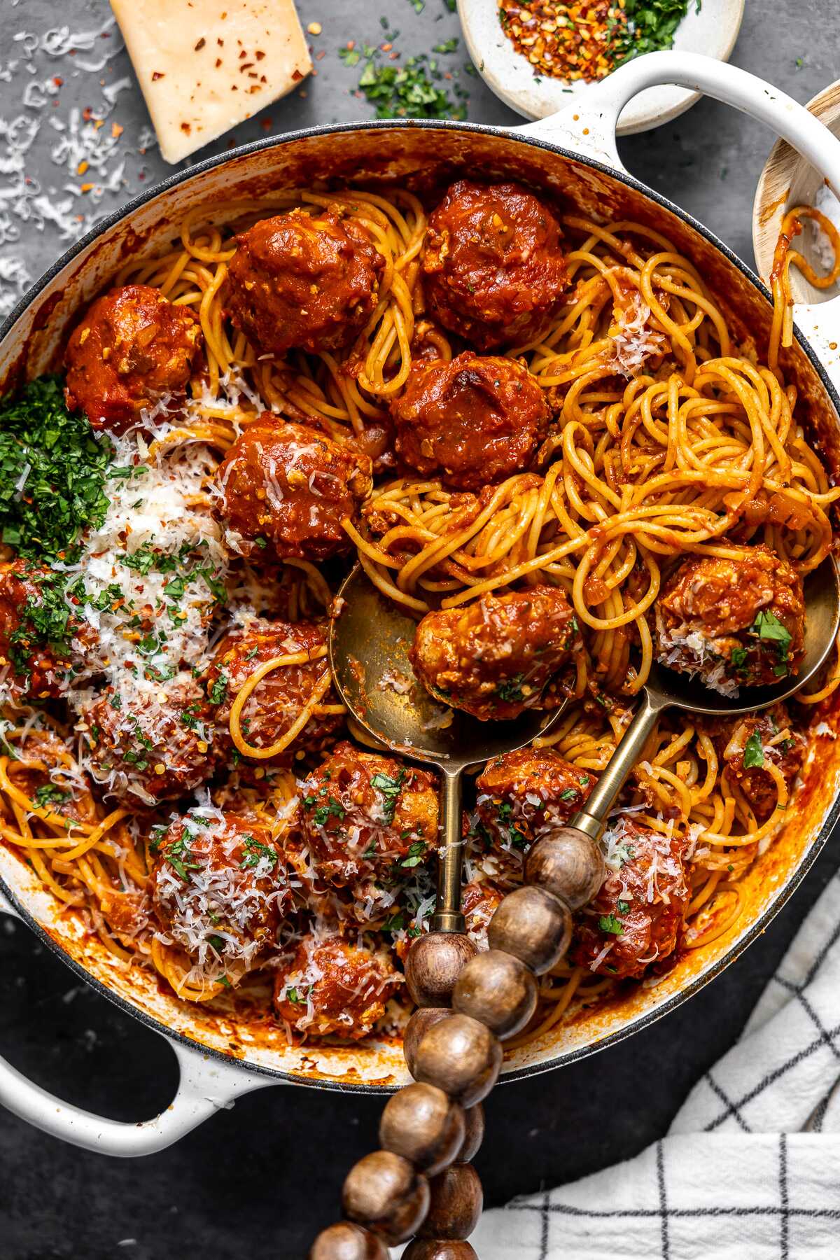 Serving spoons serving the spicy turkey meatballs and spaghetti.