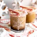 A candy cane white russian in a snowflake glass with a candy cane rim.