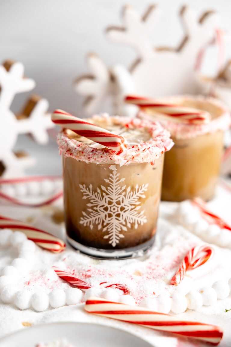 A candy cane white russian in a snowflake glass with a candy cane rim.