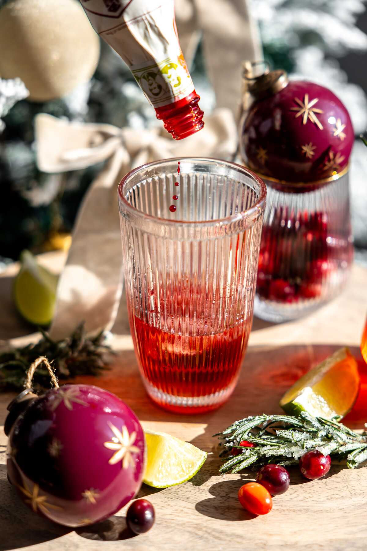 Cranberry bitters going into the cocktail shaker. 