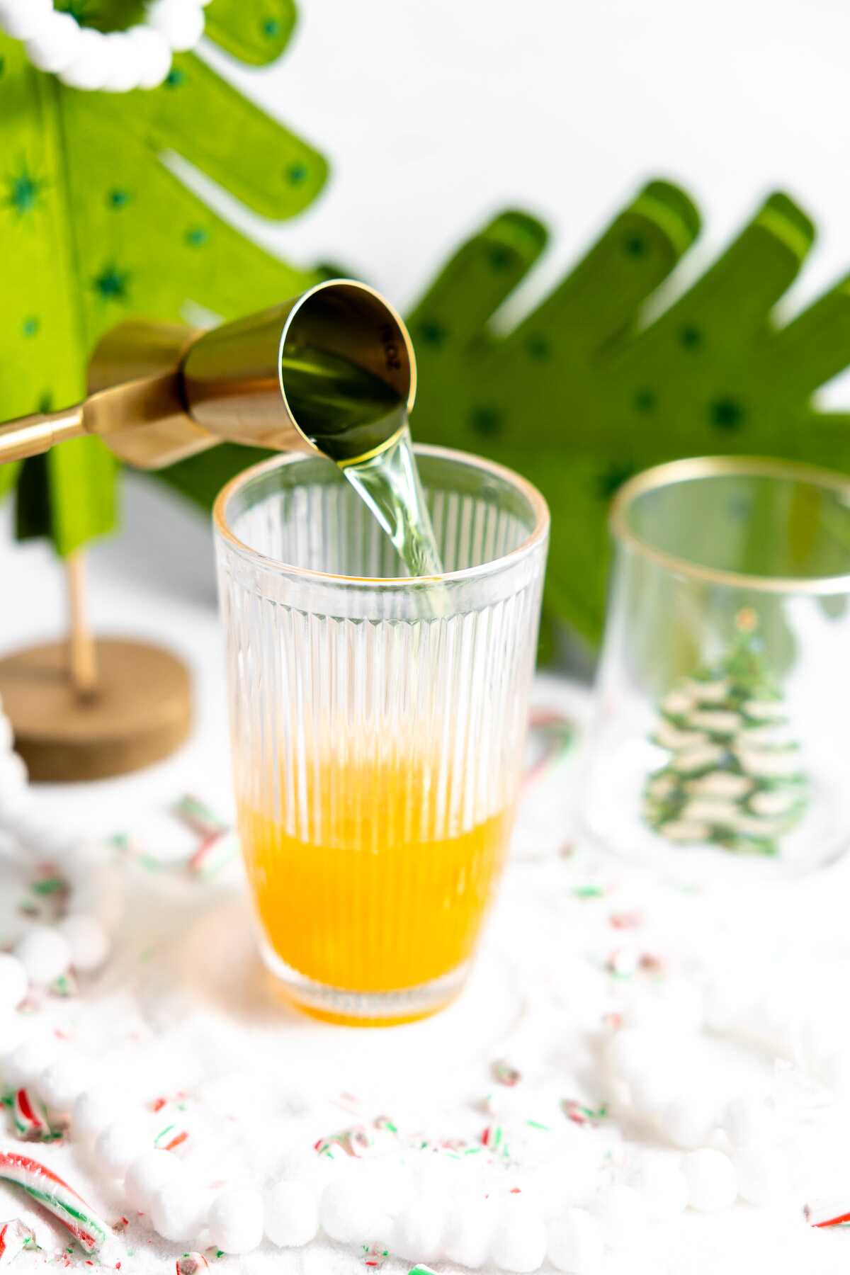 Apple Schnapps being poured into a cocktail shaker. 