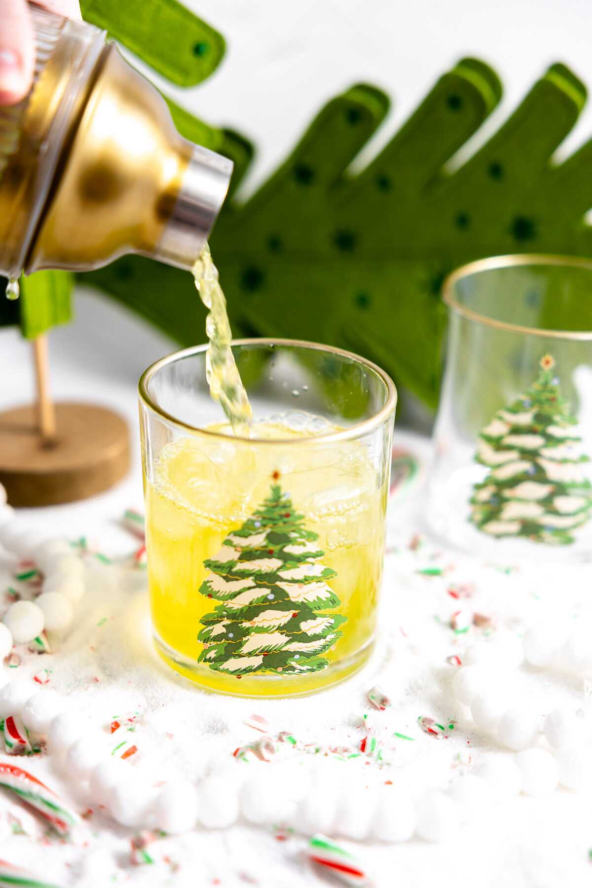 The grinch cocktail being poured into a glass. 