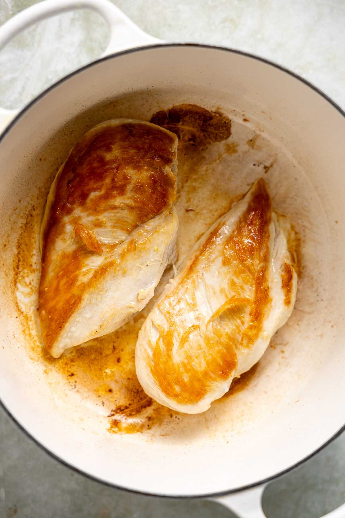 Seared chicken breasts in a pot. 
