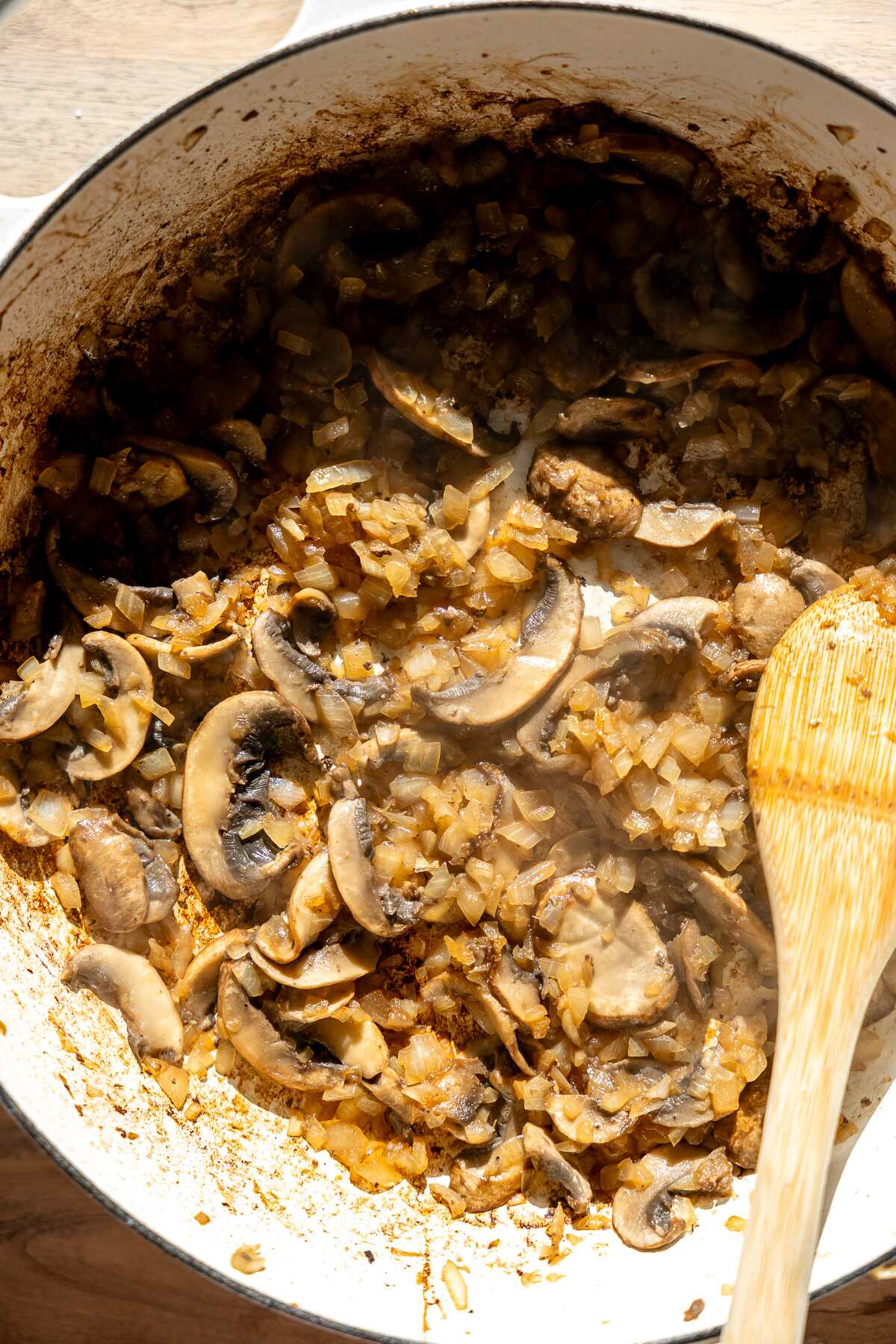 Onions and mushrooms being sautéd.