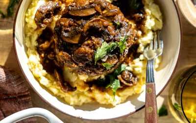 Easy salisbury steak served over a bed of mashed potatoes.